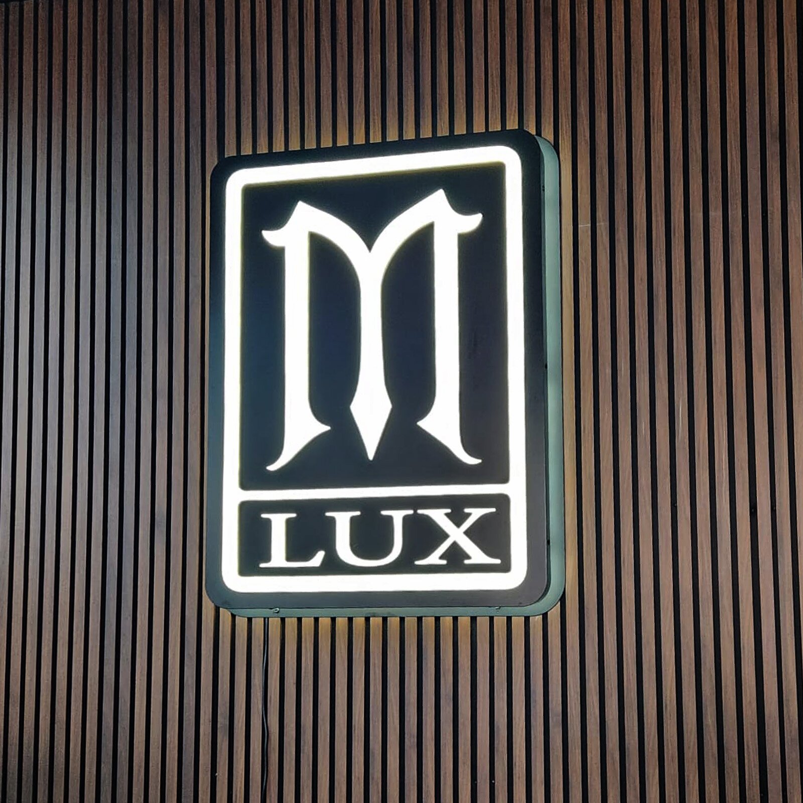 Illuminated Hook & Anchor cabinet sign mounted on a restaurant building facade