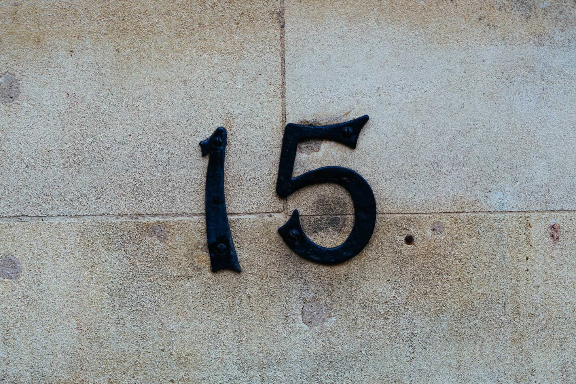 Large dimensional building address number mounted on a stone facade
