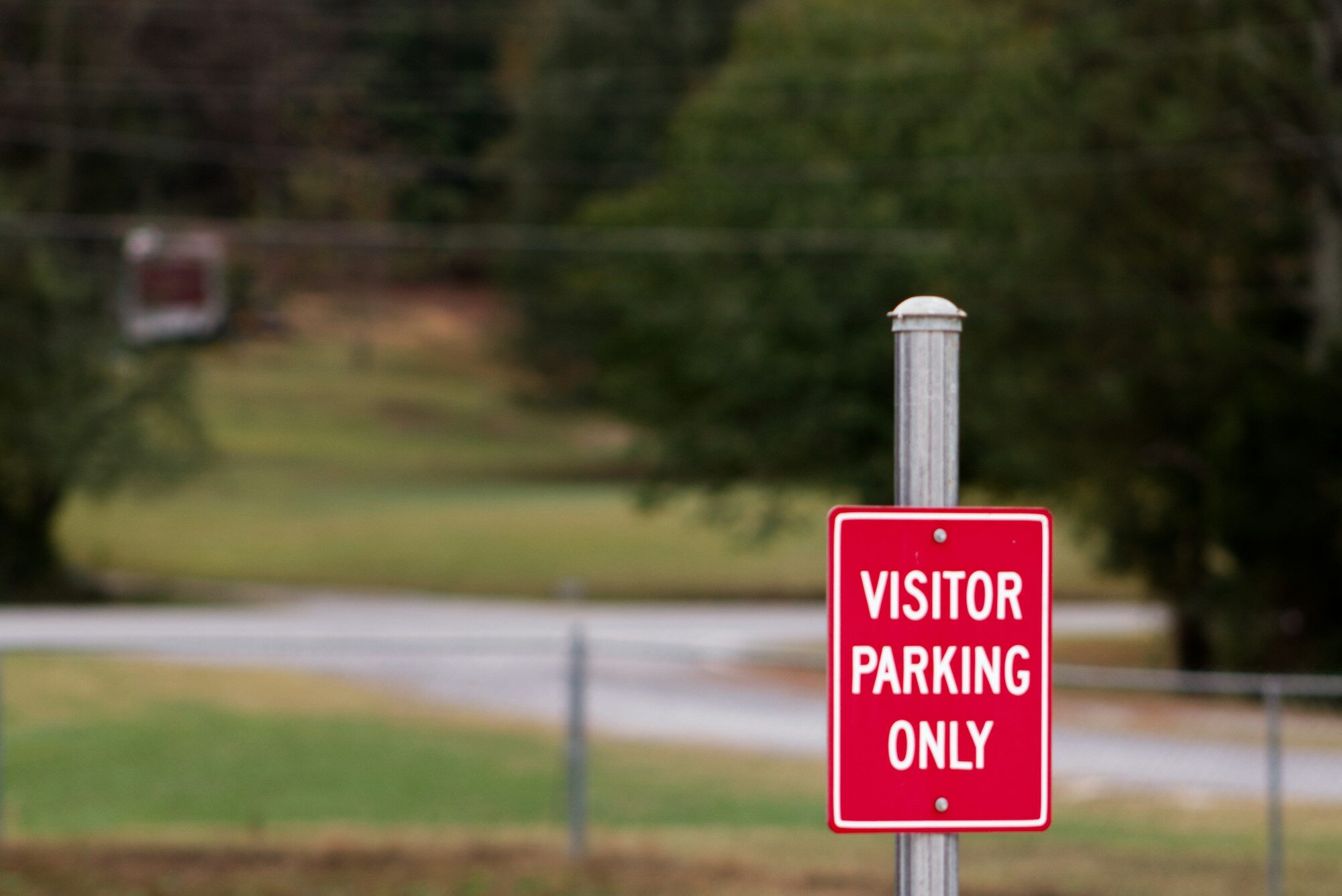 Red 'Visitor Parking Only' code-compliant lot sign
