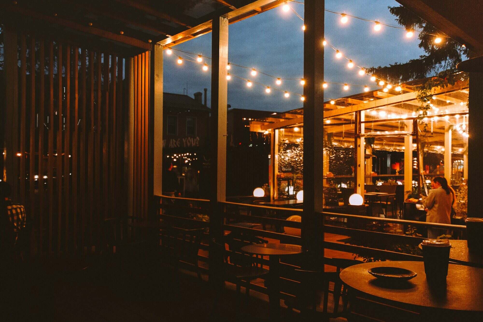 Outdoor restaurant patio with warm string lighting at dusk
