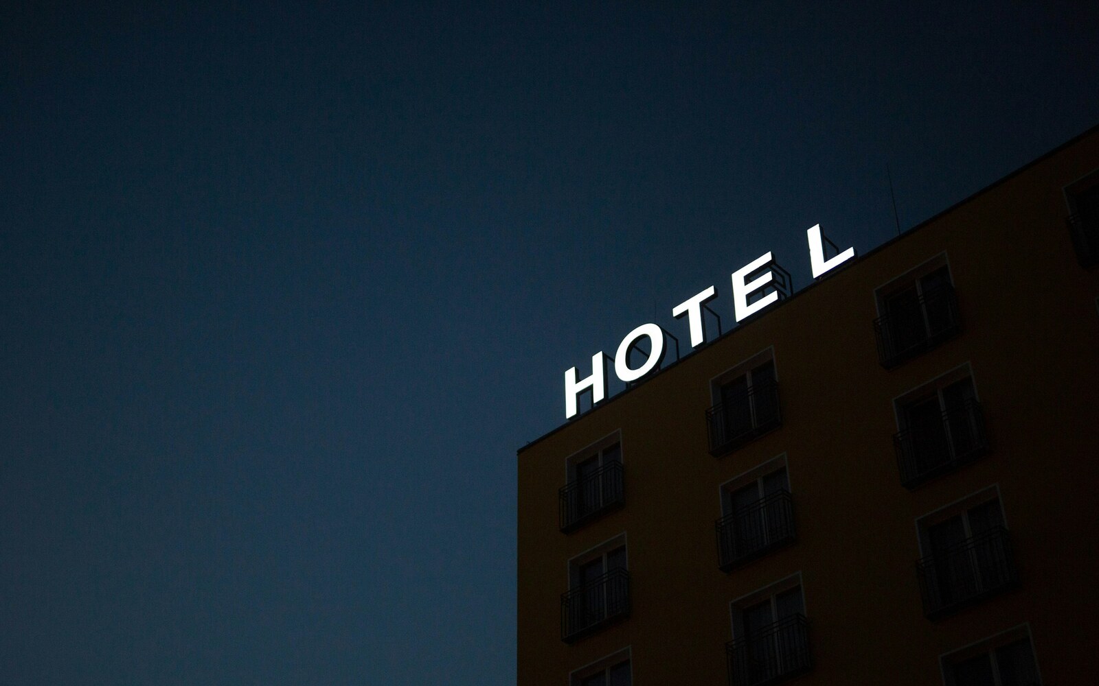 Illuminated rooftop HOTEL channel letter sign at night