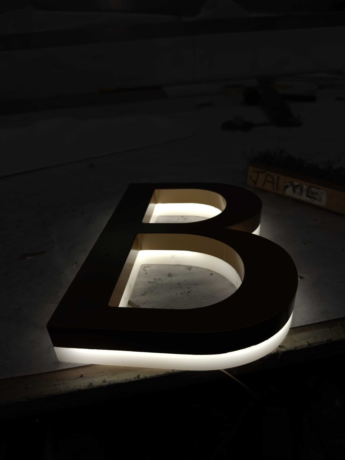 Back lit channel letters with a soft halo glow mounted on a Los Angeles building facade at dusk