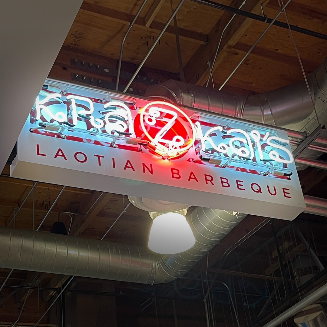 Hand-bent glass neon sign glowing warm red in a Los Angeles bar window