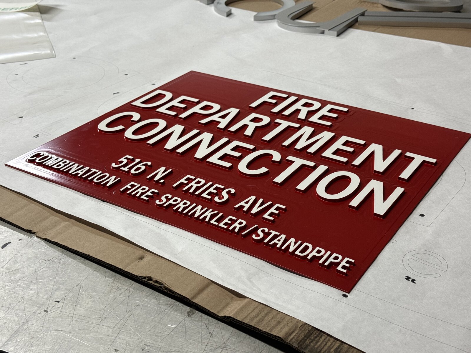 Brushed aluminum flat-cut letter set installed on a painted interior wall