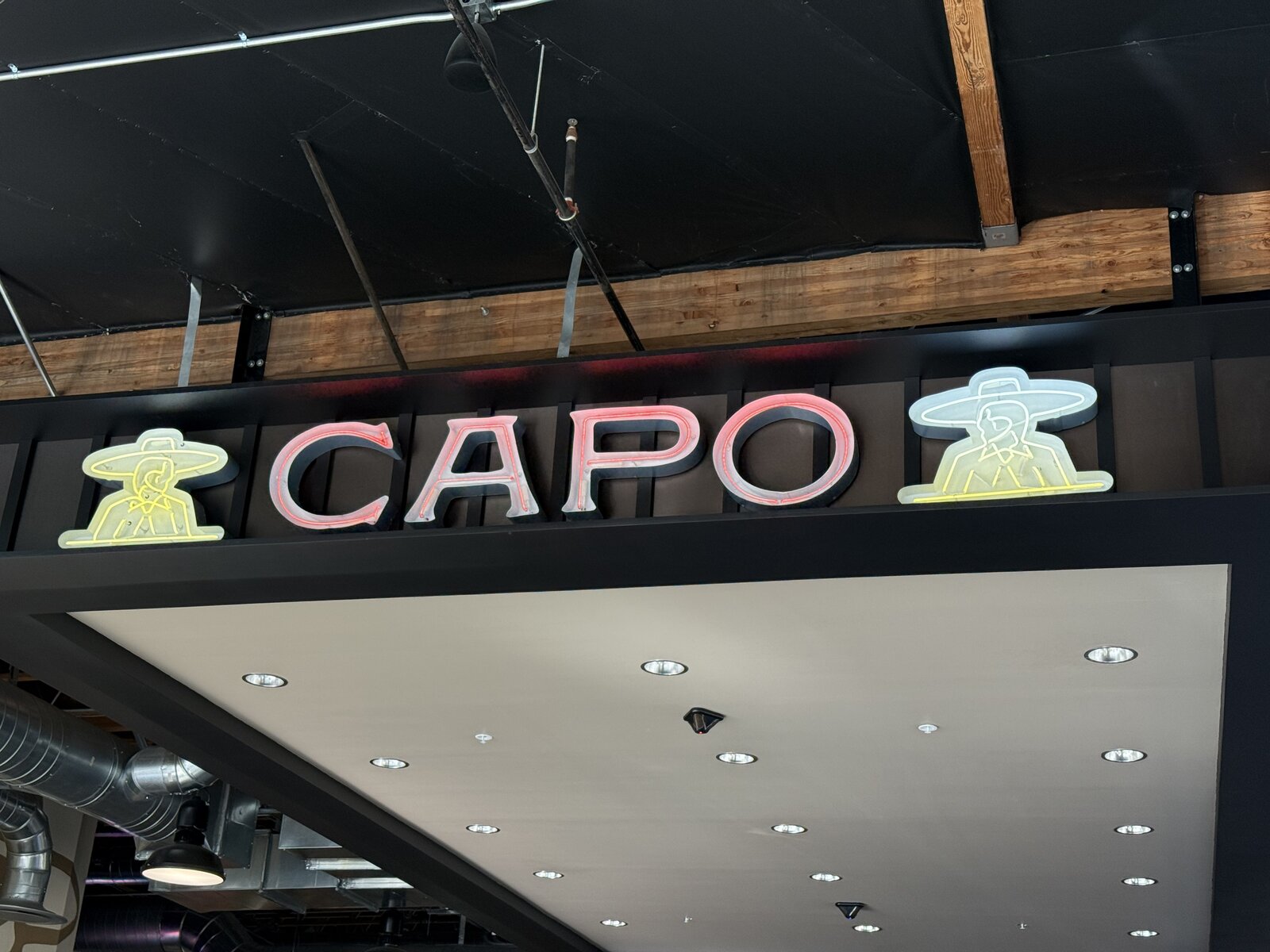 Open neon channel letters with glowing exposed tubing on a Los Angeles facade