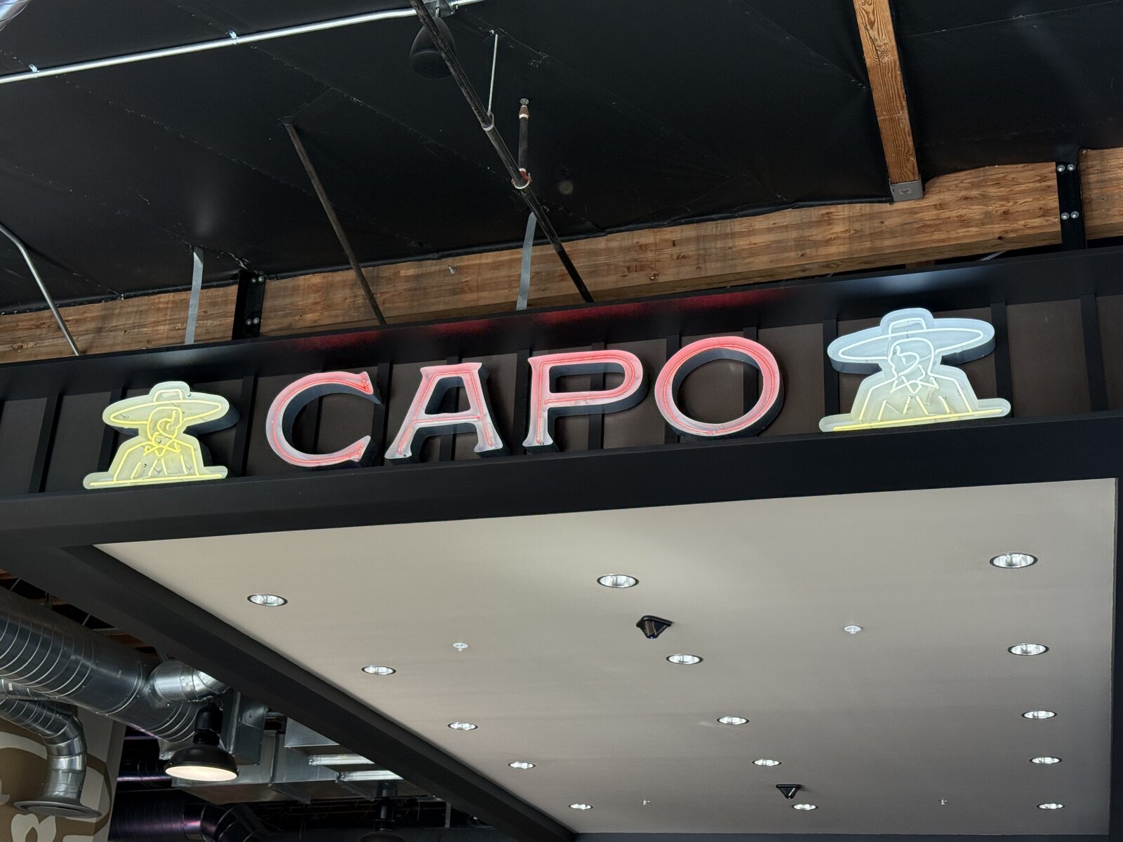 Retro open neon channel letters mounted on a dark painted backer