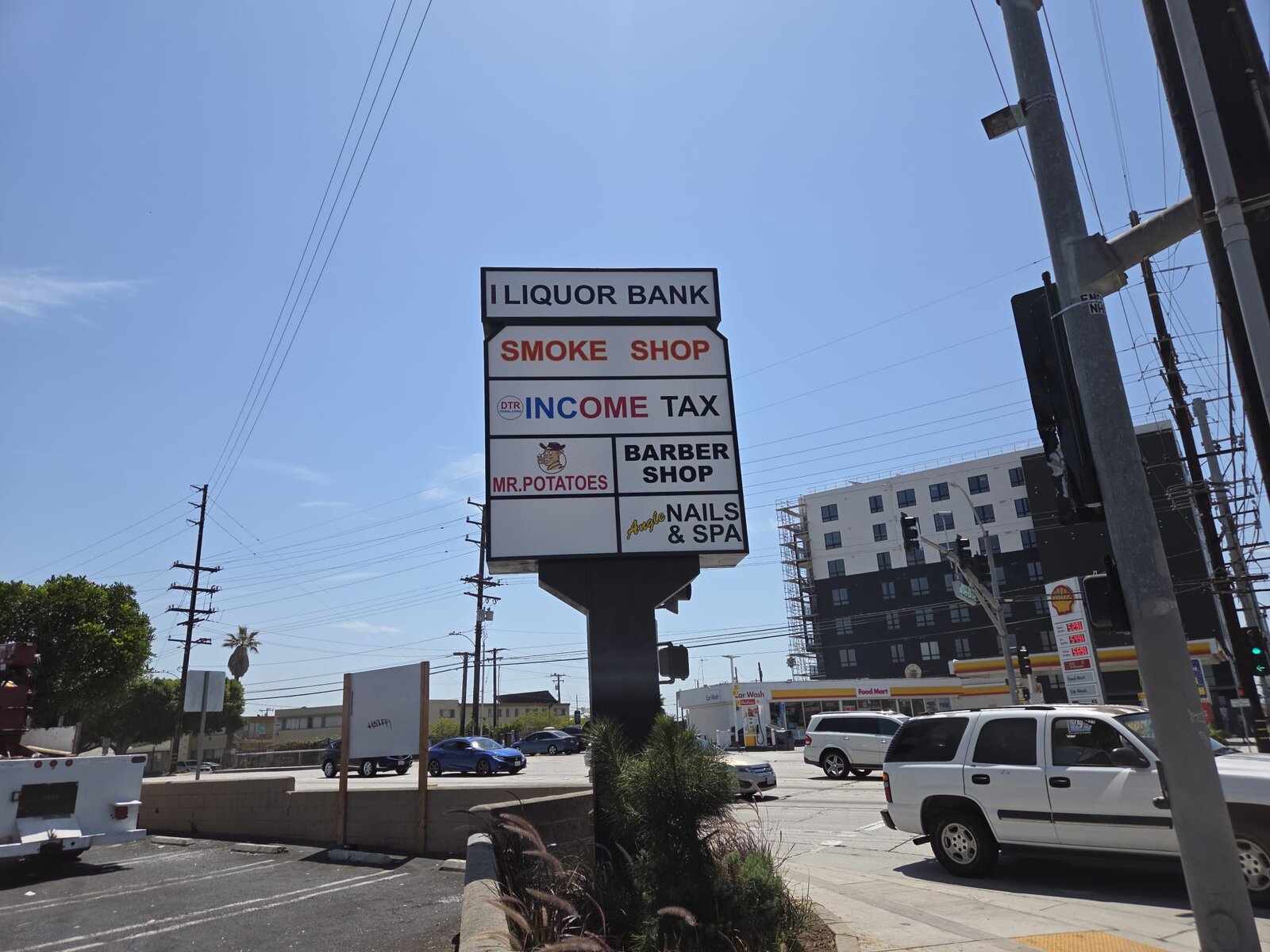 Commercial pole sign installed above a parking lot with illuminated face