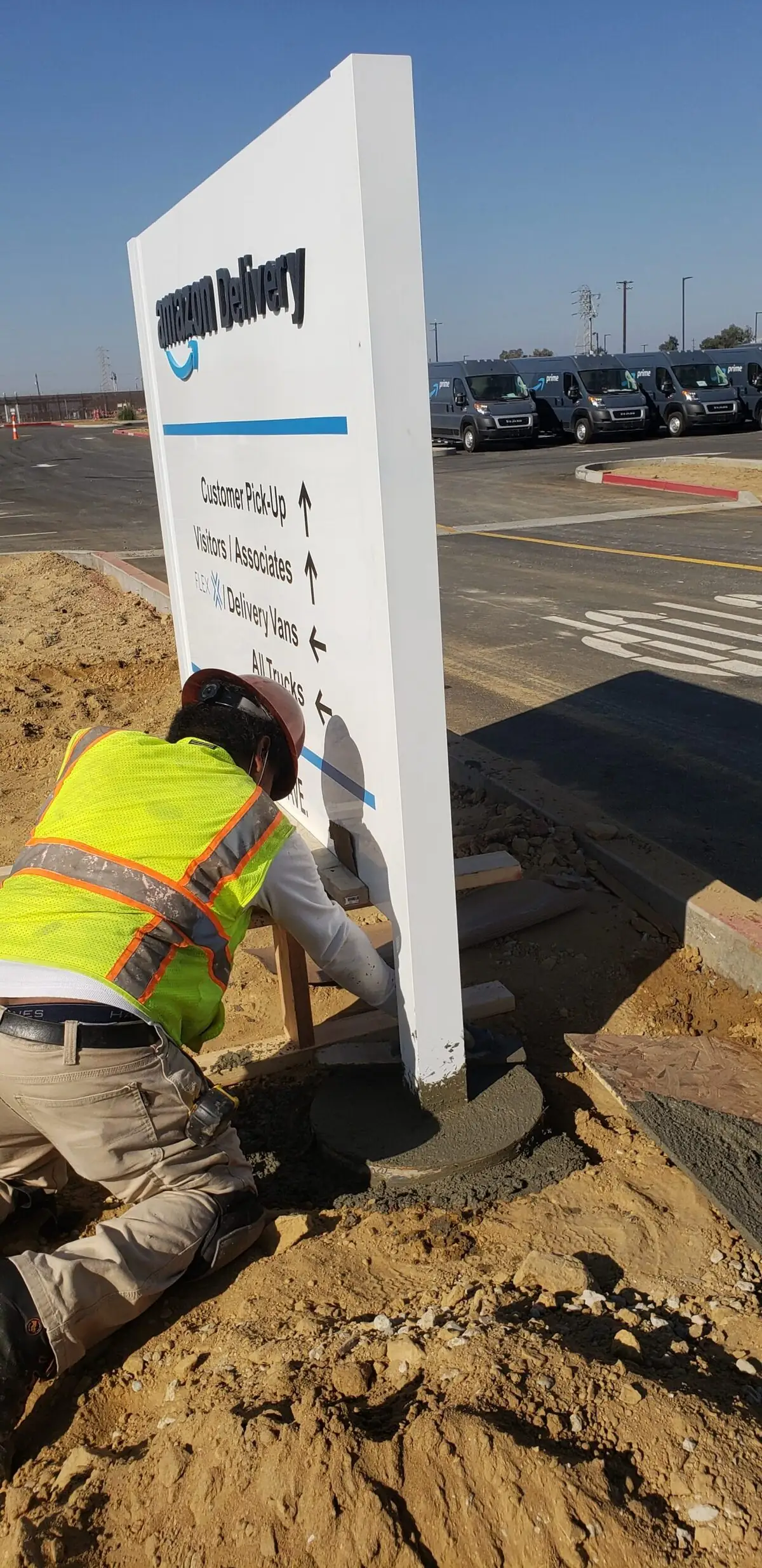 Genius Signs installer setting a newly fabricated Amazon Delivery monument sign into its foundation