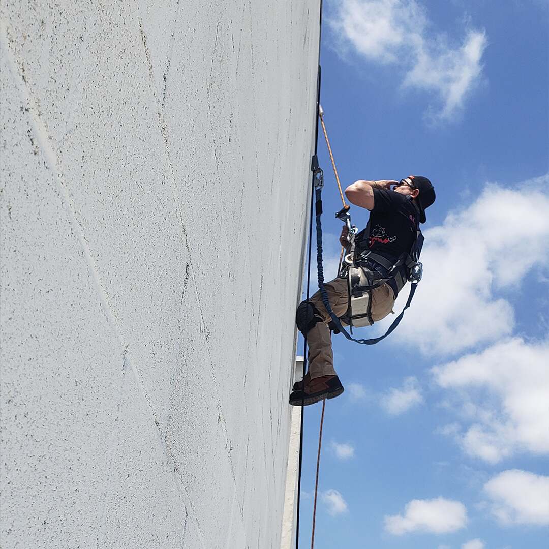 Technician servicing commercial sign on building
