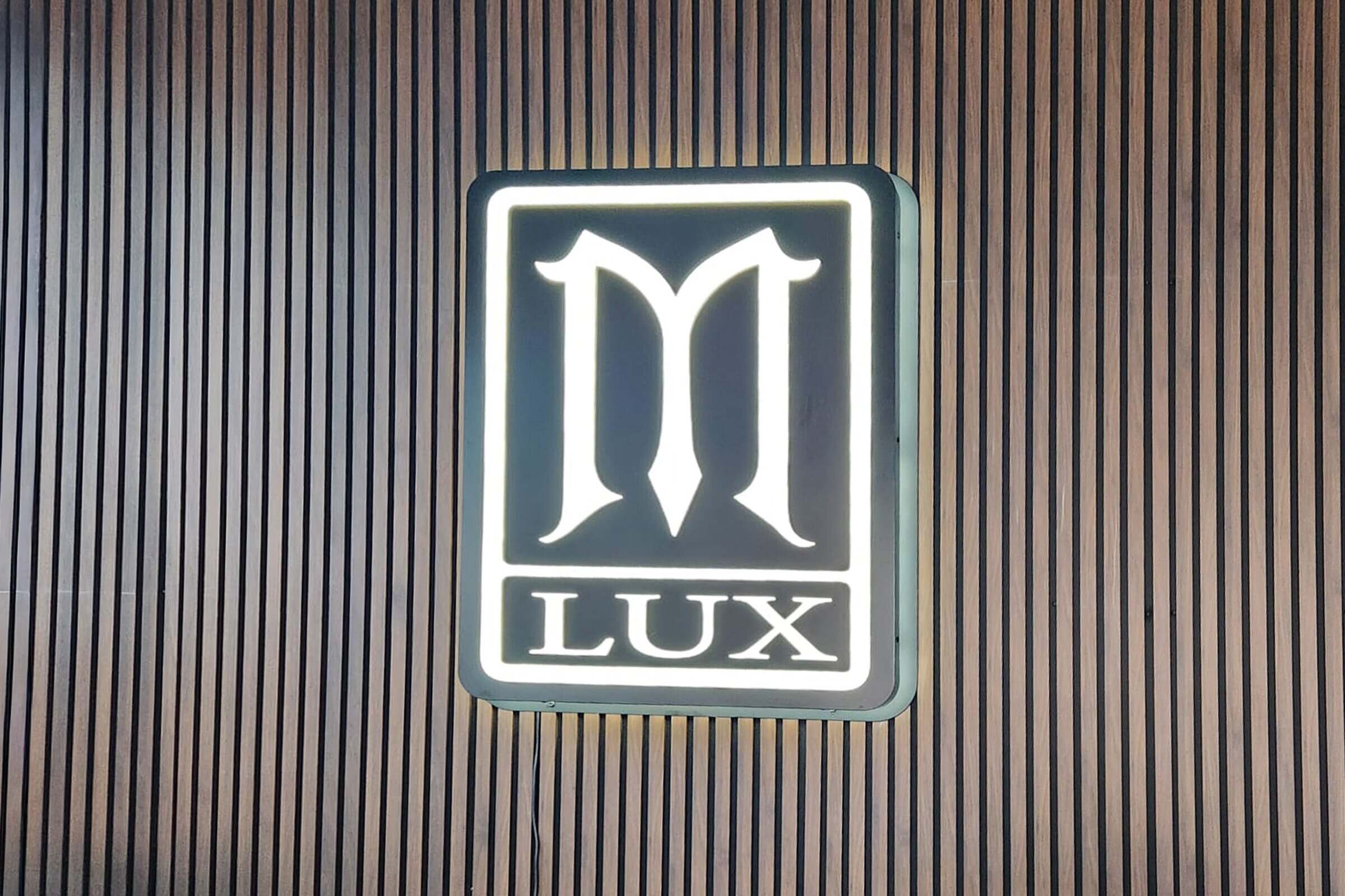 Illuminated aluminum cabinet sign mounted on a commercial storefront
