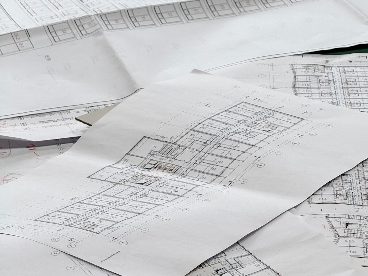 Architectural floor-plan blueprints spread across a work surface