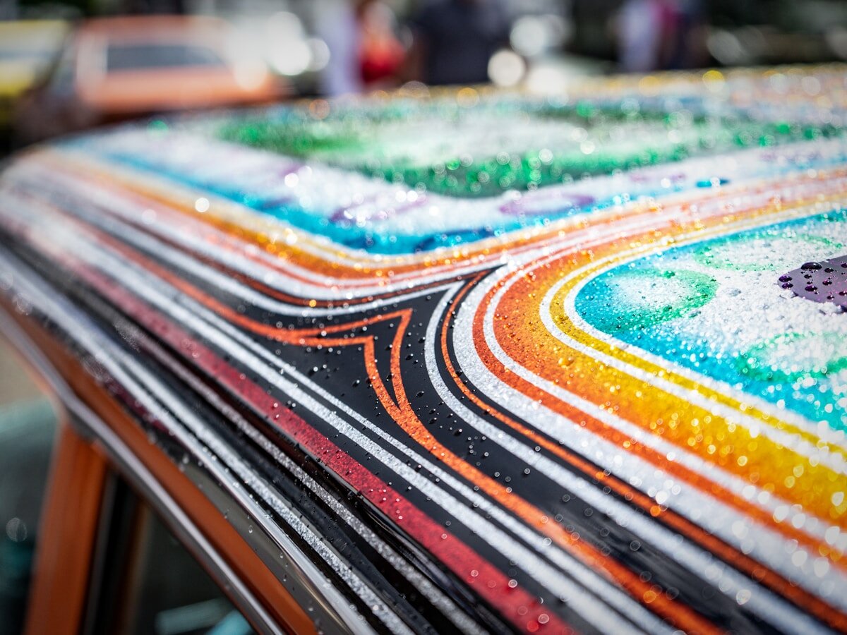 Colorful rainbow vinyl graphics striping across a vehicle roof