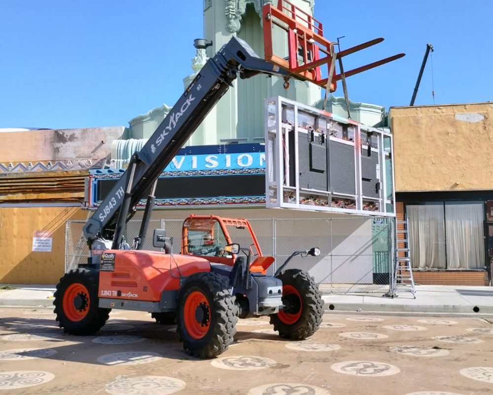 Skyjack lifting a display panel for a signage project, demonstrating efficient installation of large-scale advertising infrastructure.